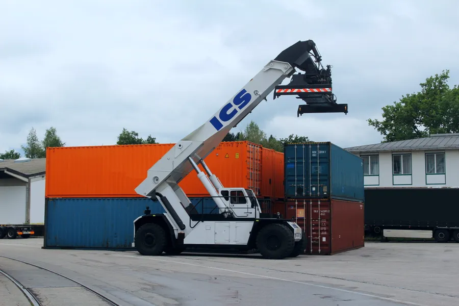 ICS-Reachstacker beim Containerumschlag, im Vordergrund die Gleise des Umschlagplatzes