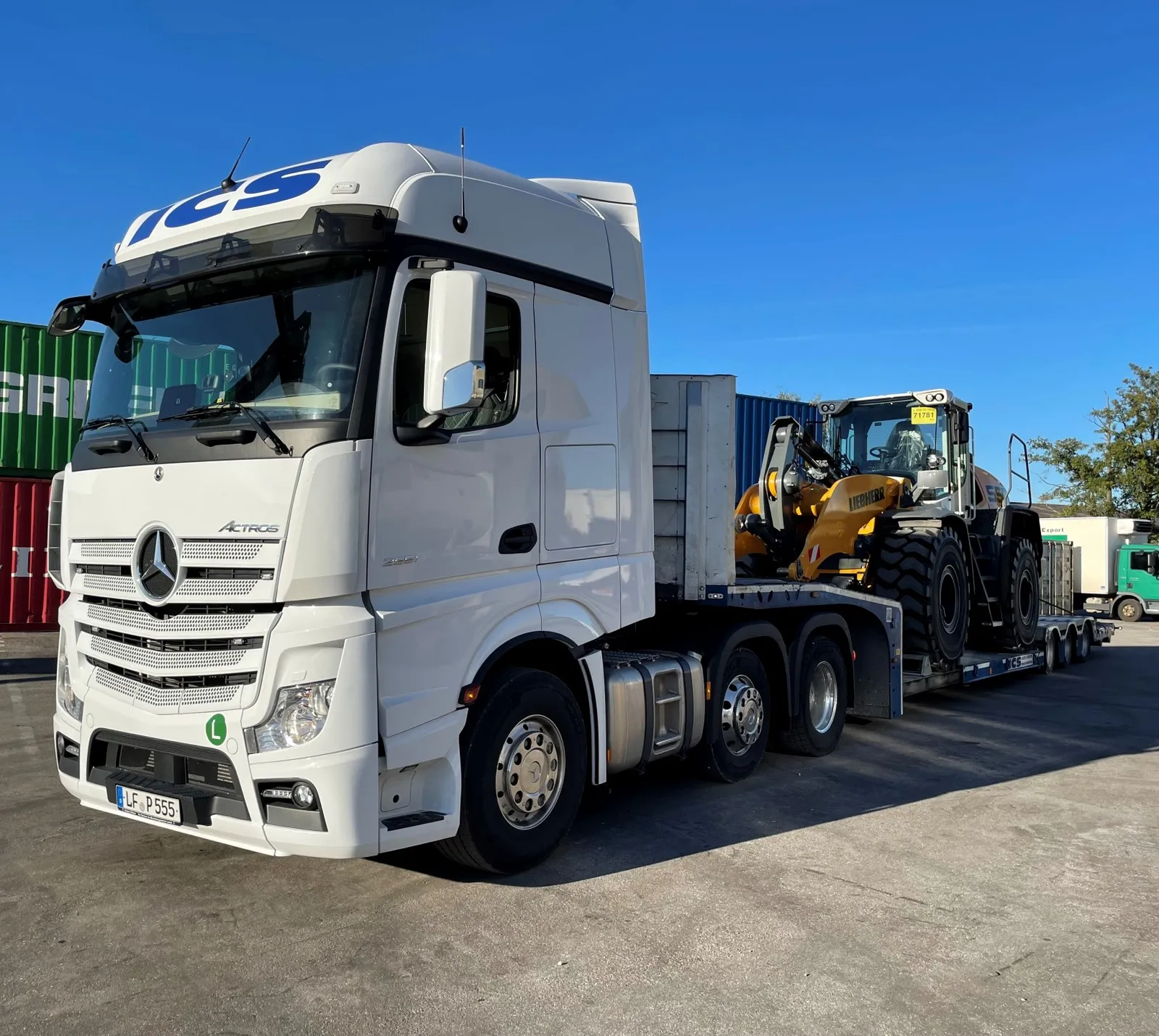 ICS-Sattelzugmaschine mit Spezialtieflader transportiert einen Radlader