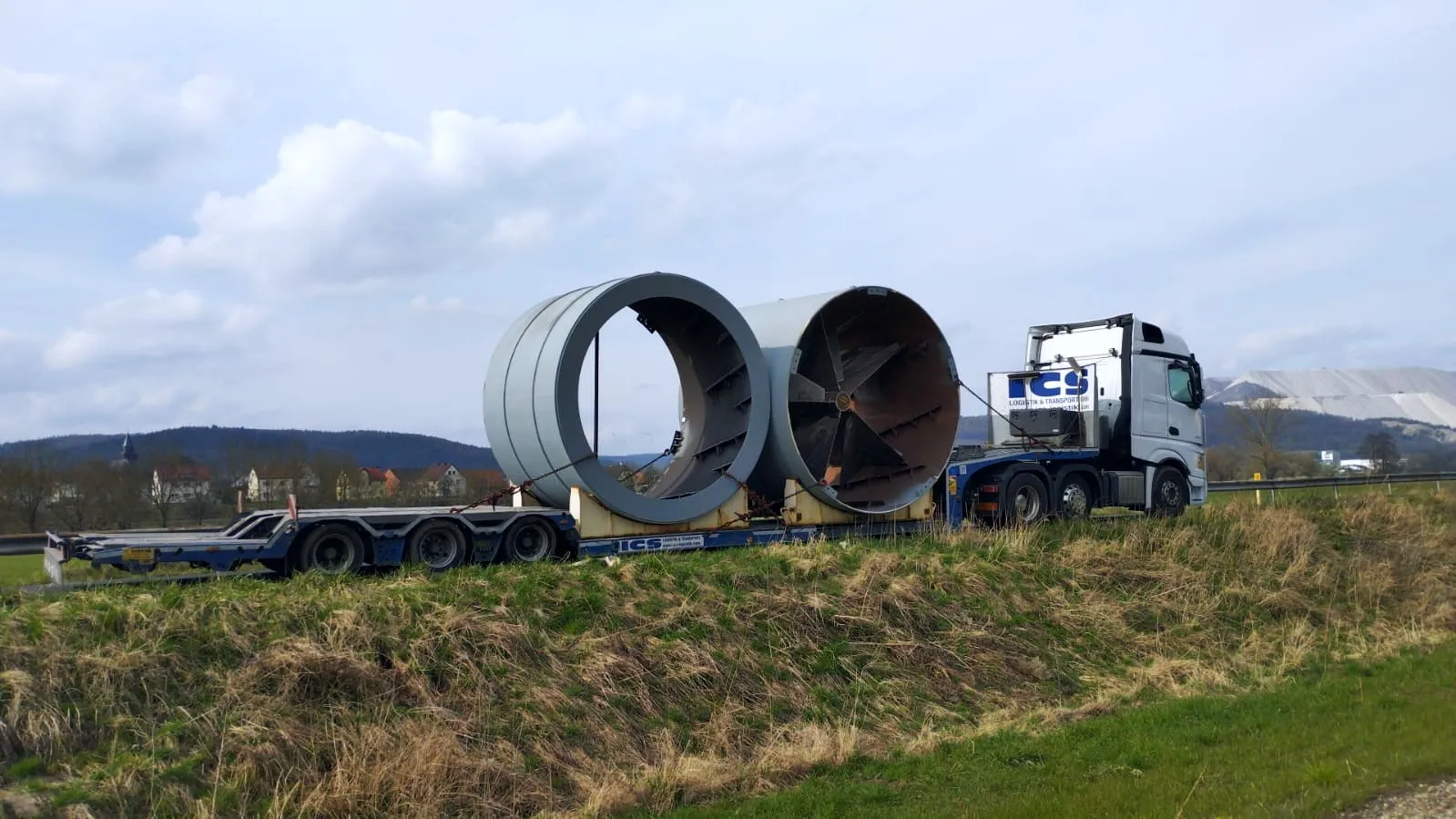 ICS-Sattelzugmaschine mit Tieflader transportiert zwei überbreite Stahlzylinder